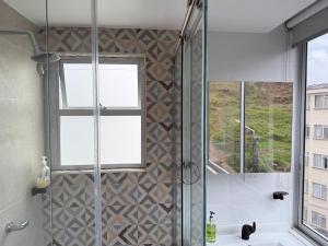 a bathroom with a shower with a sink and a window at Casa Aurora in Manizales +5 photos