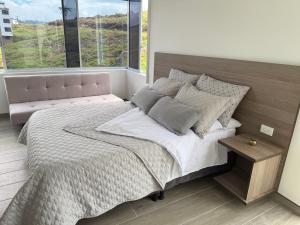 a bedroom with a large bed and a window at Casa Aurora in Manizales