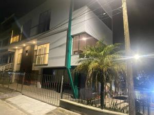 a white building with palm trees in front of it at Casa Aurora in Manizales