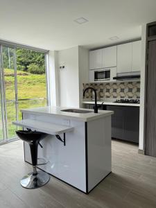 a white kitchen with a sink and a counter at Casa Aurora in Manizales