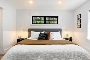 a bedroom with a large bed with white walls at The Kingfisher Lodge in Cornell +38 photos