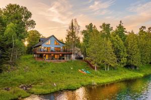 a house on a hill next to a river at The Kingfisher Lodge in Cornell