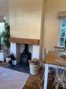 a living room with a fireplace and a table at Hollylea Cottage - New Forest in Godshill