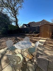 a table and chairs sitting on a patio at Hollylea Cottage - New Forest in Godshill