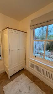 a room with a white cabinet and a window at Hollylea Cottage - New Forest in Godshill