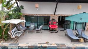 a patio with chairs and umbrellas next to a pool at villa km22 in Assinie +5 photos
