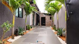 a walkway with palm trees and a building at villa km22 in Assinie