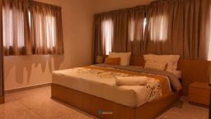 a large bed in a room with windows at villa km22 in Assinie