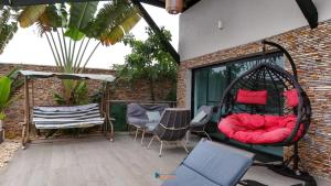 an outdoor patio with chairs and a swing at villa km22 in Assinie