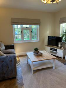 a living room with a coffee table and a tv at Hollylea Cottage - New Forest in Godshill