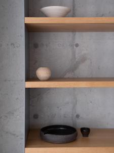 a shelf with a bowl and bowls on it at Kai House in Lun