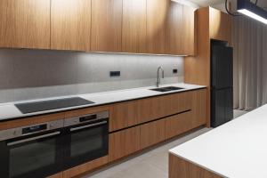 a kitchen with wooden cabinets and a sink and a refrigerator at Kai House in Lun