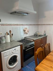 a kitchen with a washing machine and a sink at Charming Blue House in Furnas