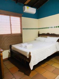 a bedroom with a large bed with towels on it at Hotel San Andrés Mompox Ubicados en el Centro Histórico in Mompos
