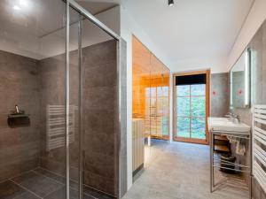 a bathroom with a glass shower and a sink at Ahorn Mountainlodge in Donnersbachwald +42 photos
