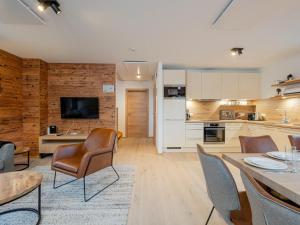 a kitchen and living room with a table and chairs at Ahorn Mountainlodge in Donnersbachwald