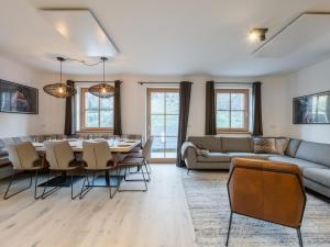 a living room with a table and chairs and a couch at Ahorn Mountainlodge in Donnersbachwald