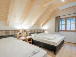 two beds in a room with wooden ceilings at Ahorn Mountainlodge in Donnersbachwald