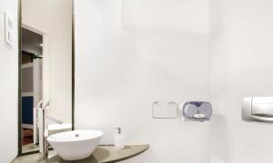 
a white sink sitting under a mirror in a bathroom at Rodamon Barcelona Hostel in Barcelona
