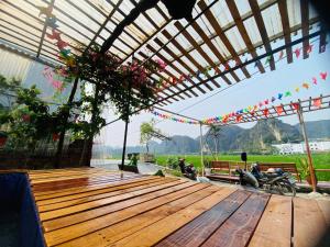 a wooden deck with motorcycles parked under a pergola at Big J Hostel in Ninh Binh