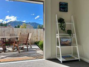 a door leading to a patio with a table and chairs at Hanmer Time in Hanmer Springs