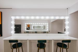 a kitchen with a counter with stools and a mirror at Meworld Hotel - Taipei Main Station in Taipei
