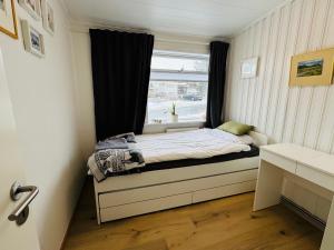 a small bedroom with a bed and a window at Langafit Guest house in Garðabær