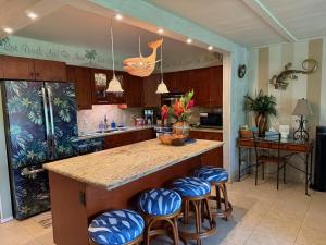 a kitchen with a island with blue stools at Unique Artist Home Steps from the Ocean in Kihei