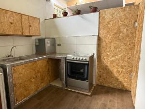a small kitchen with a stove and a sink at Casa Jardín Relax in Moyobamba