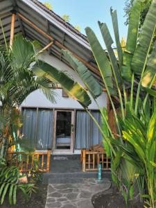 ein Haus mit vielen Palmen davor in der Unterkunft Gili Matiki, Resort & Private Villa in Gili Air