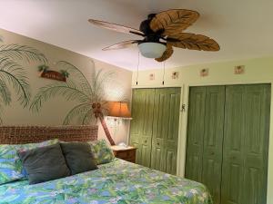 a bedroom with a ceiling fan and a bed at Unique Artist Home Steps from the Ocean in Kihei +81 photos