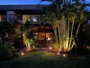 a house with a garden at night with lights at Unique Artist Home Steps from the Ocean in Kihei