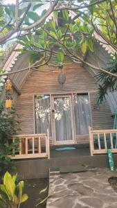 ein Holzhaus mit zwei Fenstern in einem Hof in der Unterkunft Gili Matiki, Resort & Private Villa in Gili Air