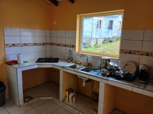 a small kitchen with a sink and a window at Maison Hibiscus in Petit-Bourg