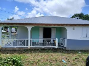 a small house with a green and white at Maison Hibiscus in Petit-Bourg