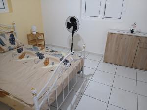 a bedroom with a bed with a fan on it at Maison Hibiscus in Petit-Bourg