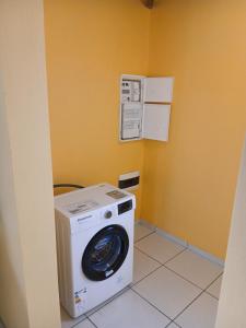 a washer and dryer in a corner of a room at Maison Hibiscus in Petit-Bourg