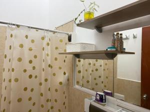 a bathroom with a shower curtain and a mirror at Casa Jardín Relax in Moyobamba +20 photos