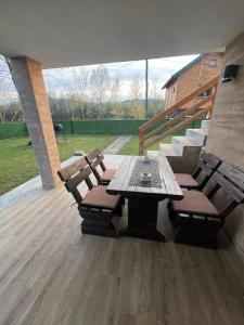 a patio with a wooden table and benches and stairs at Apartmani Fenix 29 in Ljubovija