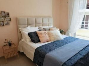 a bedroom with a large bed with pillows on it at Elena's Hotel & apartments in Sarandë