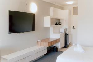 a room with a tv and a bed and a desk at Canberra Park Motel in Canberra