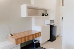 a small white kitchen with a counter and a microwave at Canberra Park Motel in Canberra +10 photos