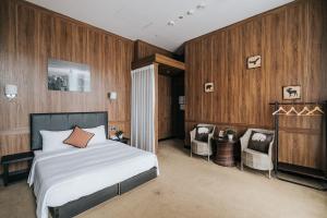 a bedroom with a bed and two chairs in it at Meworld Hotel - Taipei Main Station in Taipei