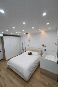 a white bedroom with a large bed and a tub at Villa Jonchère in Chanteloup-en-Brie +29 photos