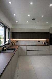 a kitchen with white cabinets and a large window at Villa Jonchère in Chanteloup-en-Brie