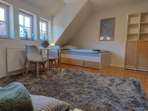 a bedroom with a bed and a table and chairs at Gästezimmer alte Schneiderei in Duderstadt