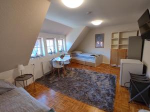 a small room with a bed and a table and chairs at Gästezimmer alte Schneiderei in Duderstadt