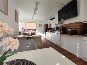 a kitchen with white cabinets and a table with chairs at Gästezimmer alte Schneiderei in Duderstadt