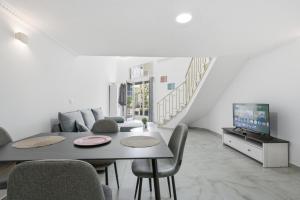 a living room with a table and chairs and a tv at The Cliff Suites in Golem