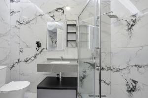 a bathroom with a sink and a glass shower at The Cliff Suites in Golem +113 photos